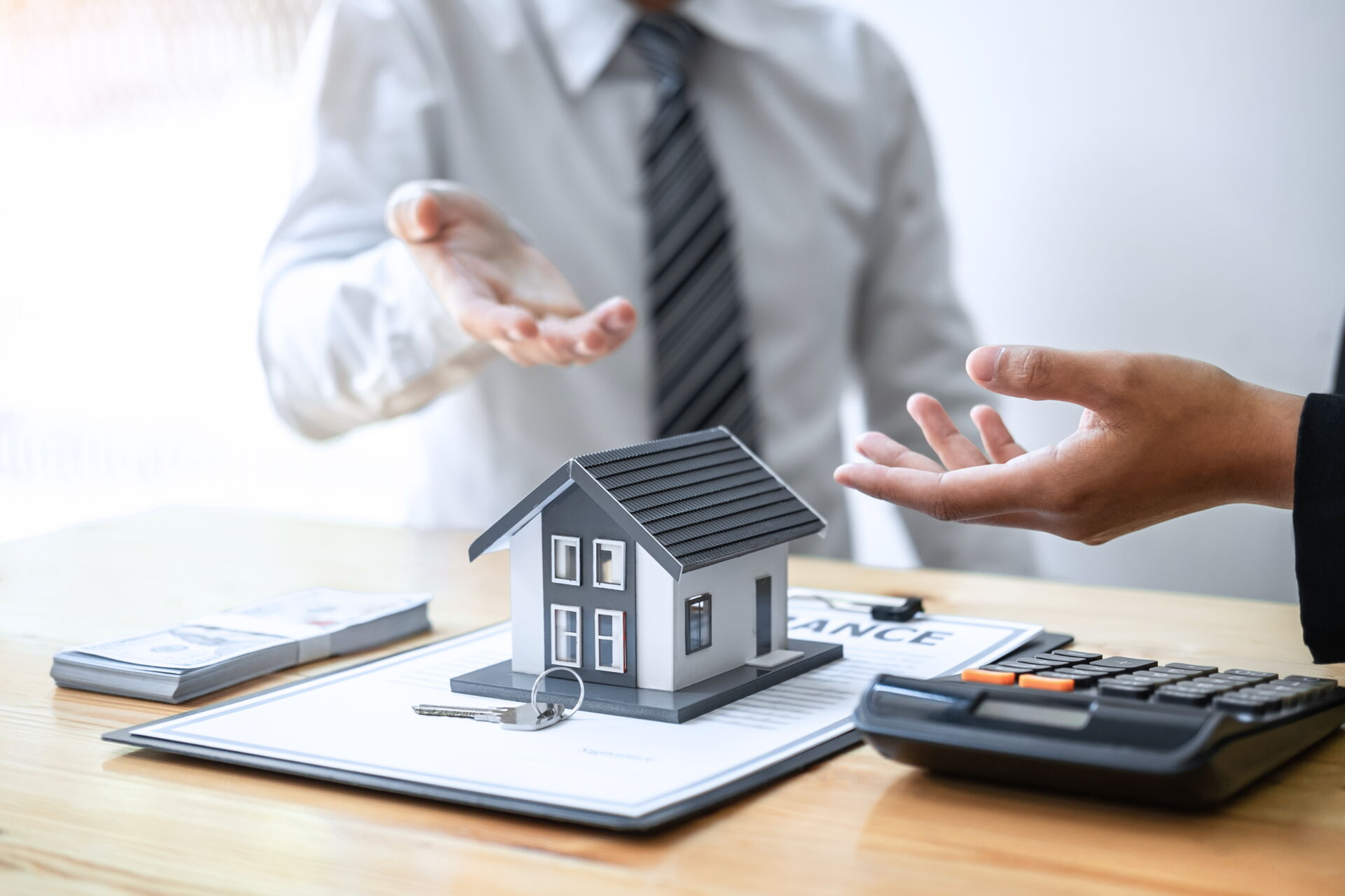 Immobilienberatung in Bautzen | Immobilien Anders GmbH Beratungsgespräch zum Immobilienkauf mit Hausmodell, Vertrag und Geld in Bautzen. Immobilien Anders GmbH – Ihr kompetenter Partner.